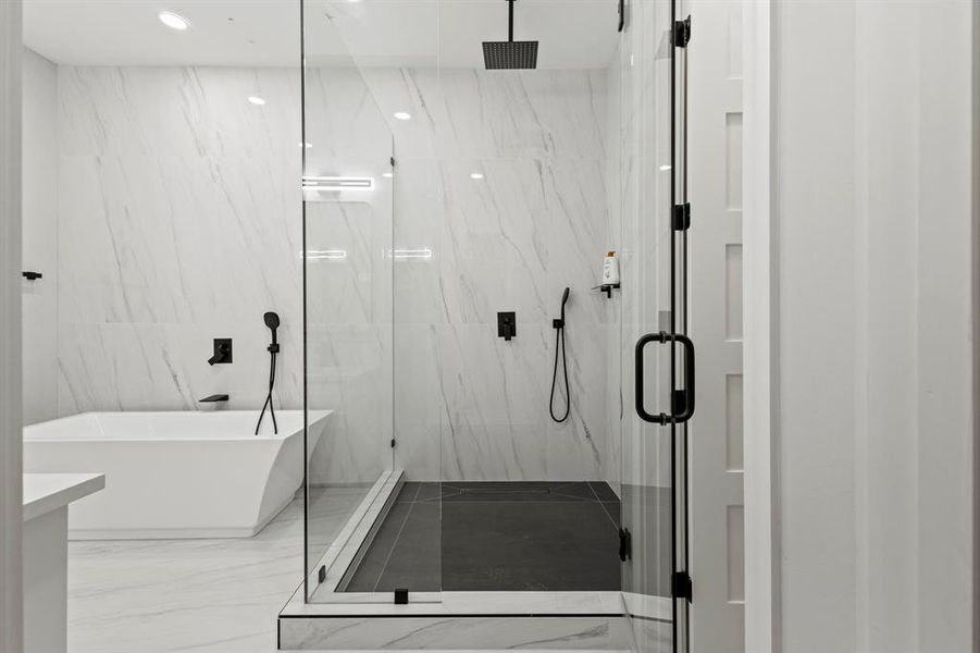 Full bathroom featuring marble tiled floors, a marble finish shower, and a soaking tub