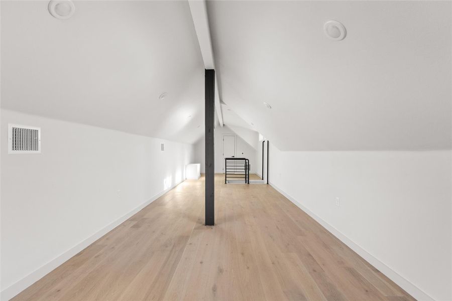 Additional living space with light wood finished floors and baseboards
