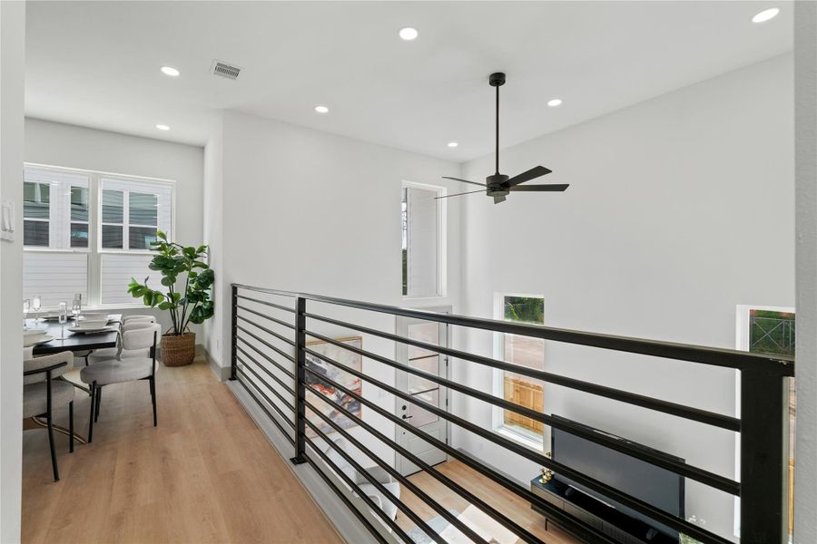 Elevated dining with a view—this airy overlook connects seamlessly to the living room below, enhanced by 18-ft ceilings, oversized windows, and sleek modern railings. Elevated dining with a view—this airy overlook connects seamlessly to the living room below, enhanced by 18-ft ceilings, oversized windows, and sleek modern railings.