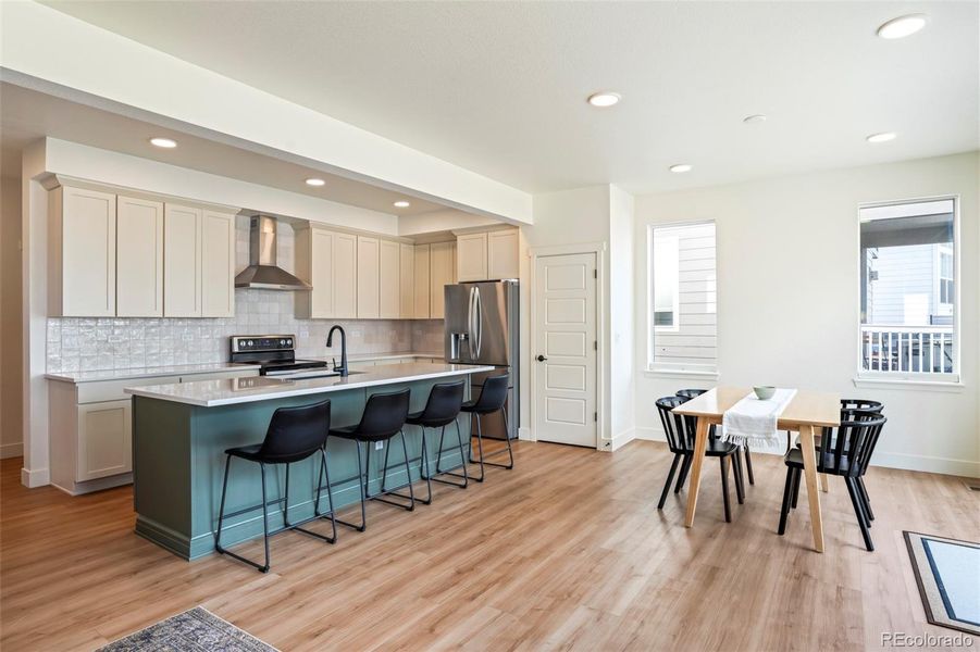 Expansive open-concept kitchen and dining area with large island seating, quartz countertops, and modern finishes designed for everyday living and entertaining