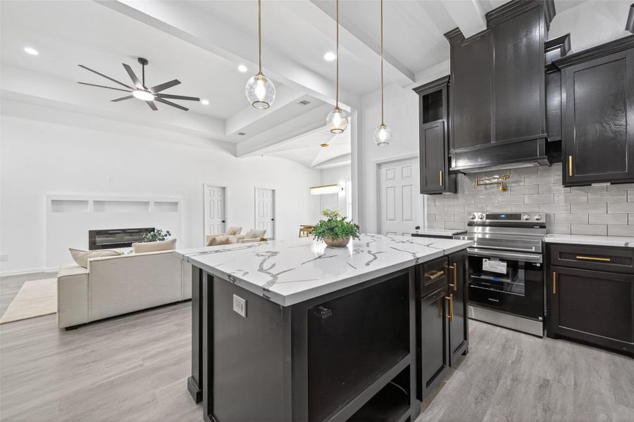 Stunning chef’s kitchen with oversized island, abundant custom cabinetry, modern finishes, and ample prep space for everyday living.