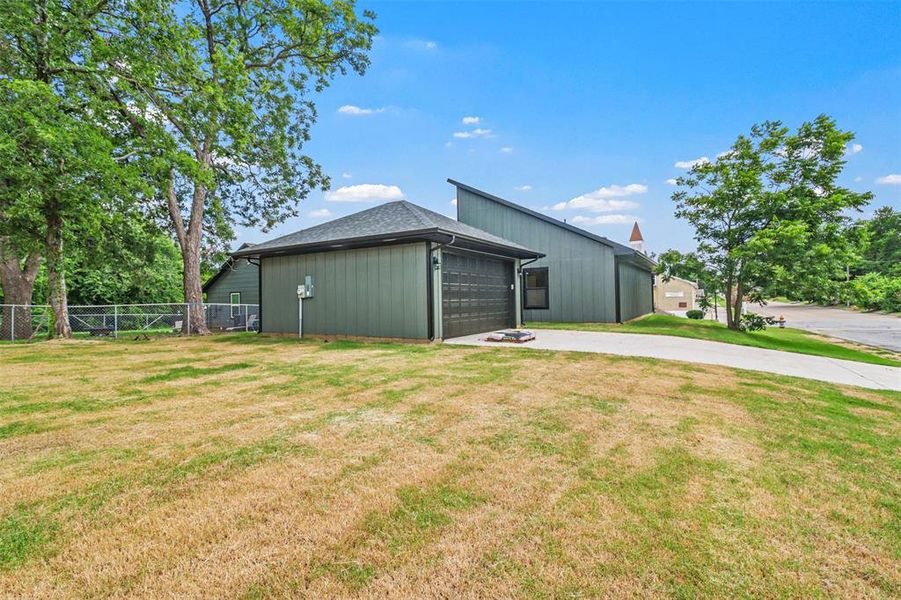 View of outdoor structure featuring a garage and a yard