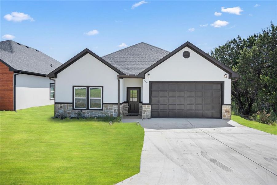 View of front of home featuring a garage and a front yard