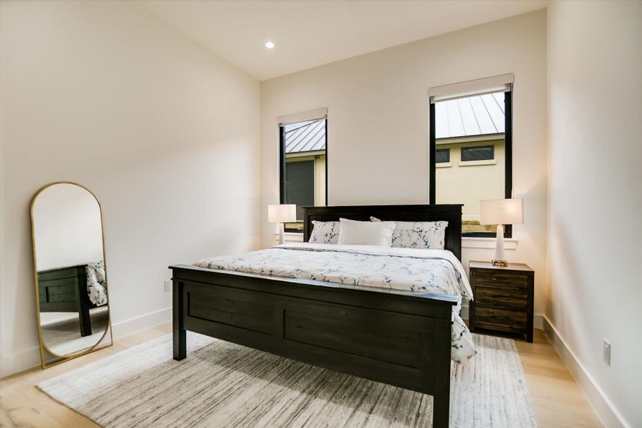 Naturally illuminated sleeping quarters, featuring light-toned flooring and tall windows.