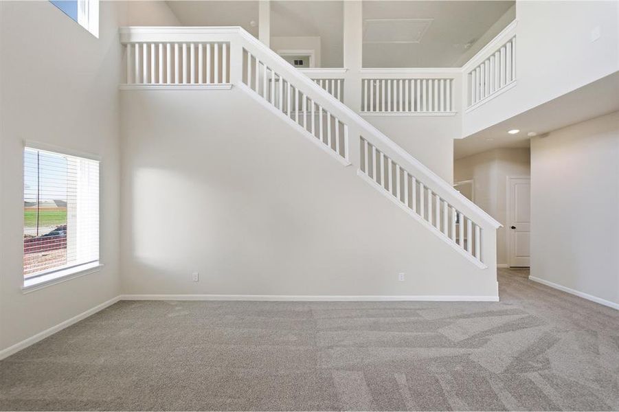 Grand entryway featuring a prominent staircase with white balusters and handrails Grand entryway featuring a prominent staircase with white balusters and handrails