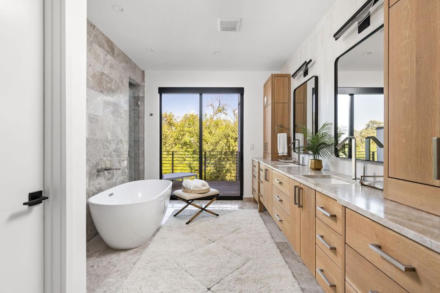 Bathroom with double vanity, a freestanding bath, tile walls, and recessed lighting Bathroom with double vanity, a freestanding bath, tile walls, and recessed lighting