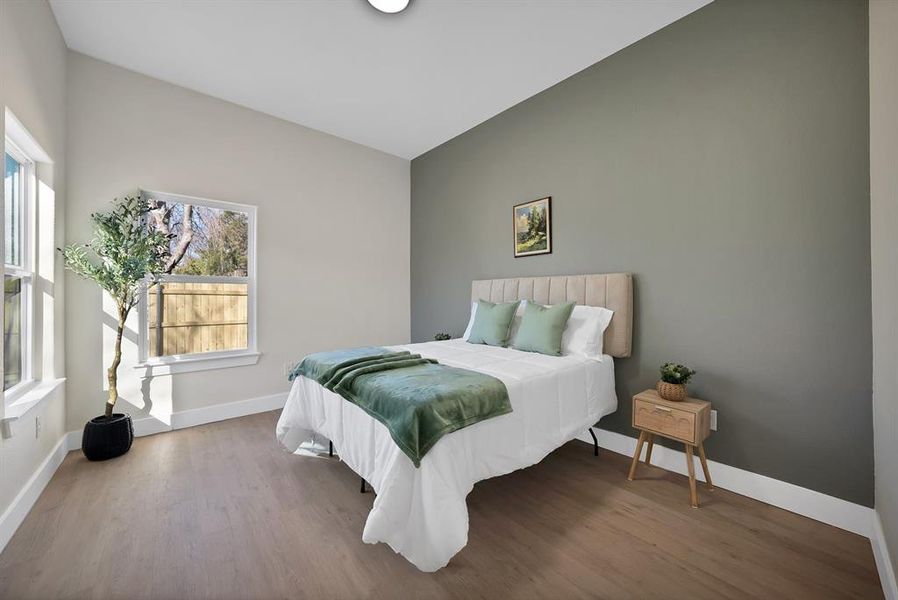 Bedroom with wood finished floors and baseboards