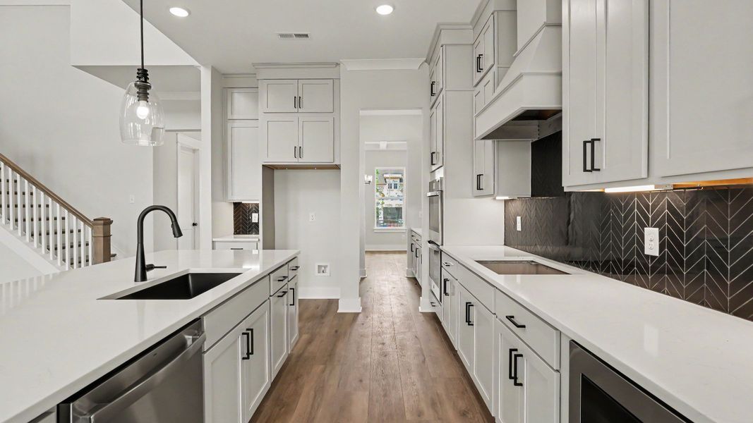 Kitchen with quartz countertops, pendant lighting, and tile backsplash Kitchen with quartz countertops, pendant lighting, and tile backsplash