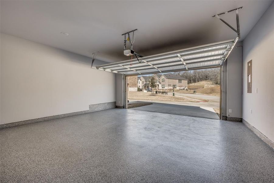 Garage featuring baseboards and a garage door opener