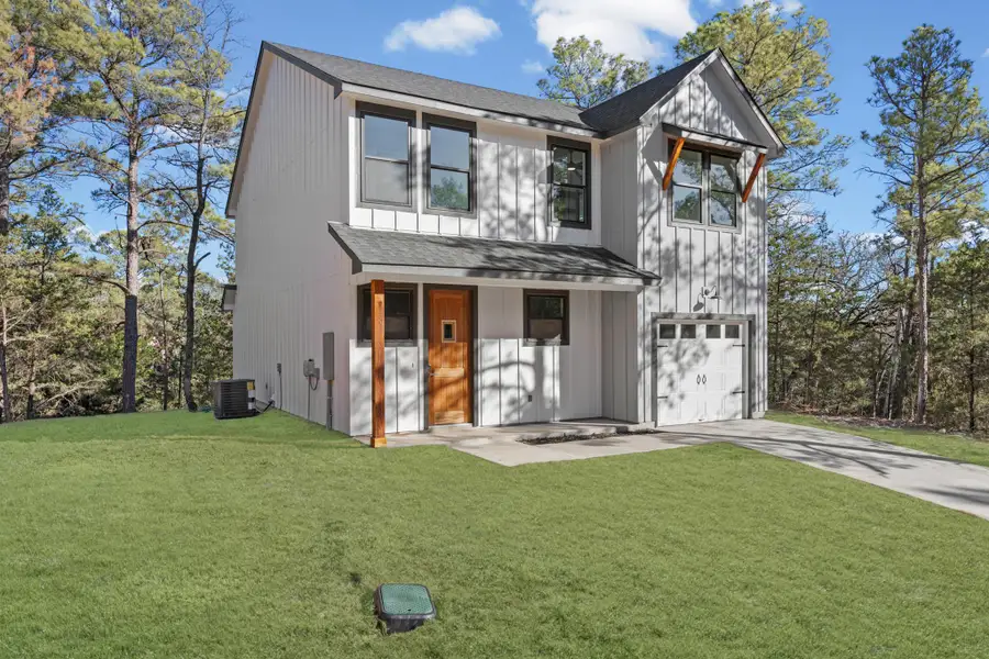 Modern inspired farmhouse featuring roof with shingles, a front lawn, a porch, and driveway