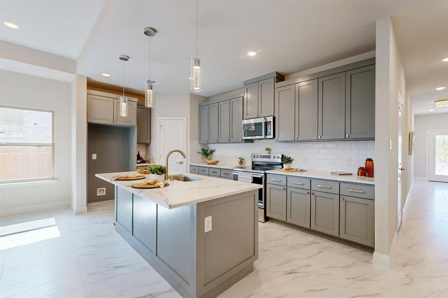 Kitchen with a center island with sink, appliances with stainless steel finishes, sink, and plenty of natural light