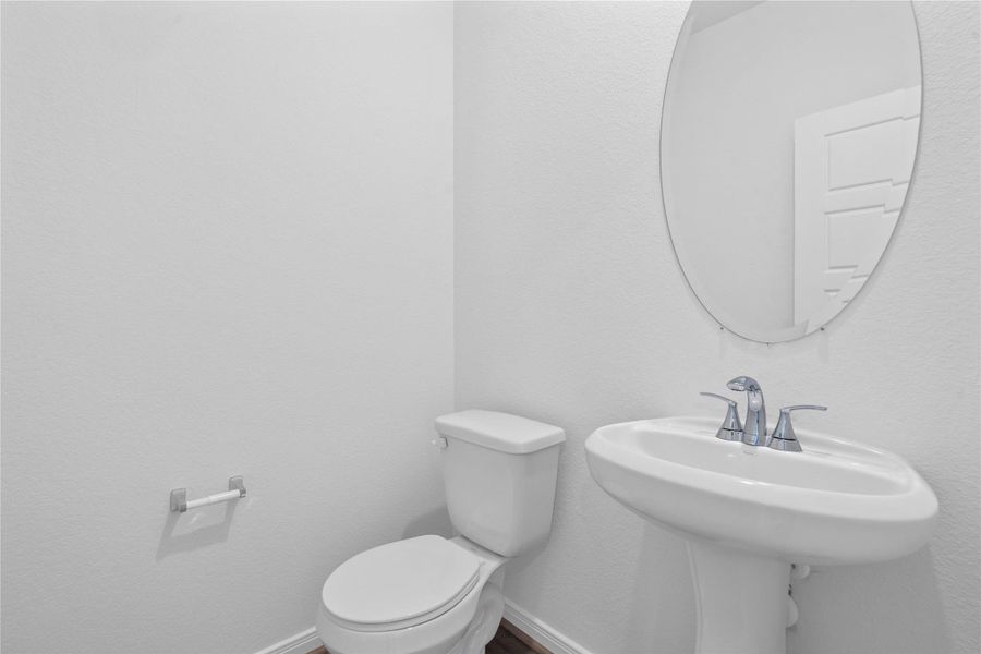 The powder room on the first floor includes a pedestal sink, oval mirror, and toilet to conveniently meet your needs. The powder room on the first floor includes a pedestal sink, oval mirror, and toilet to conveniently meet your needs.