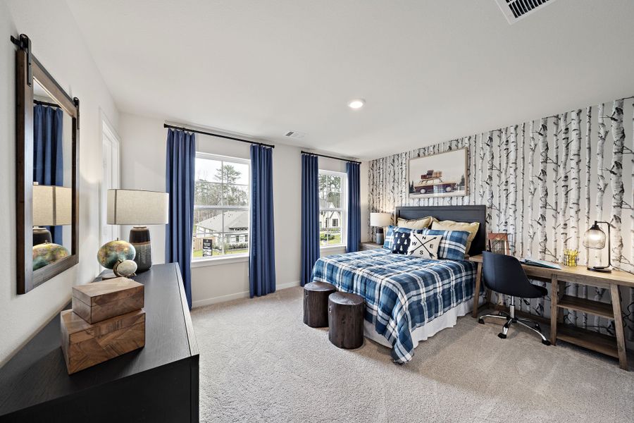 A bedroom with a bed and a desk.