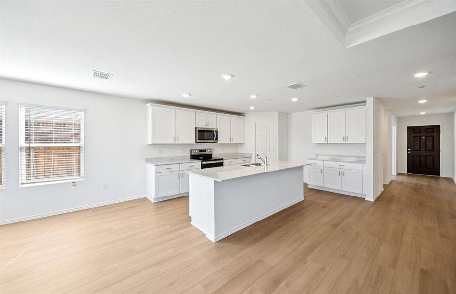 Large island overlooking gathering room and dining areas