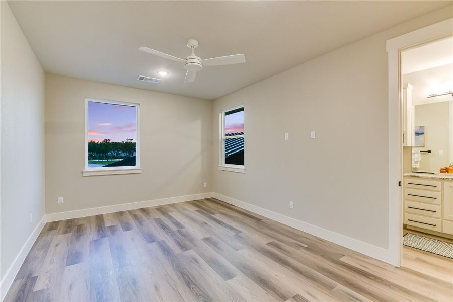 Bedroom 2 with light wood-type flooring and a ceiling fan Bedroom 2 with light wood-type flooring and a ceiling fan