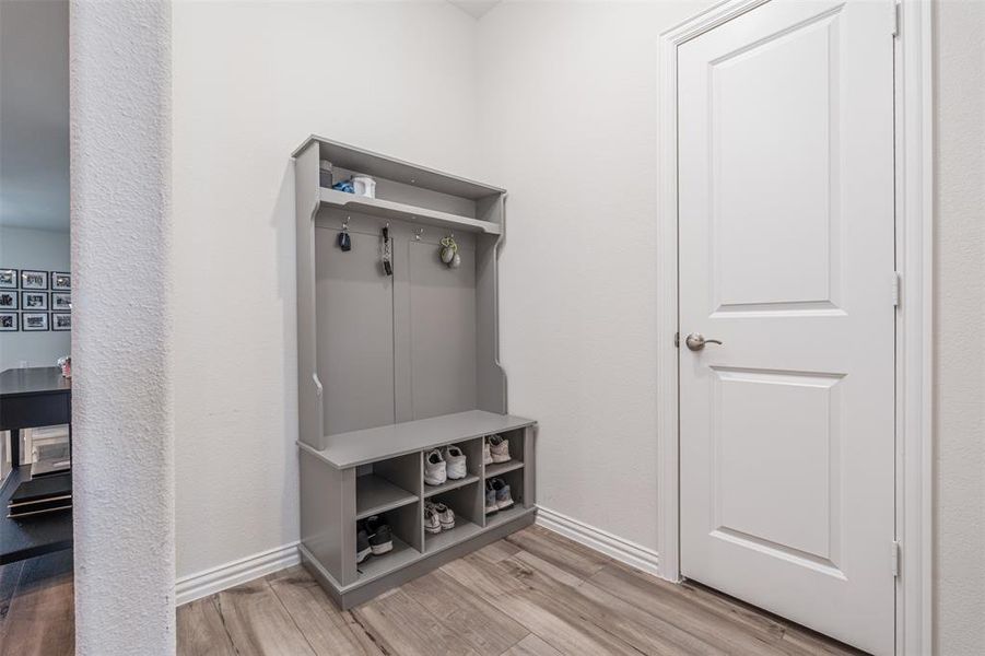 Mudroom featuring light wood-style floors and baseboards