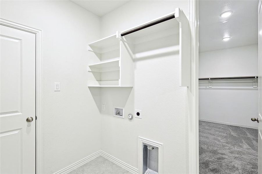 Washroom with hookup for a washing machine, hookup for a gas dryer, hookup for an electric dryer, and light colored carpet