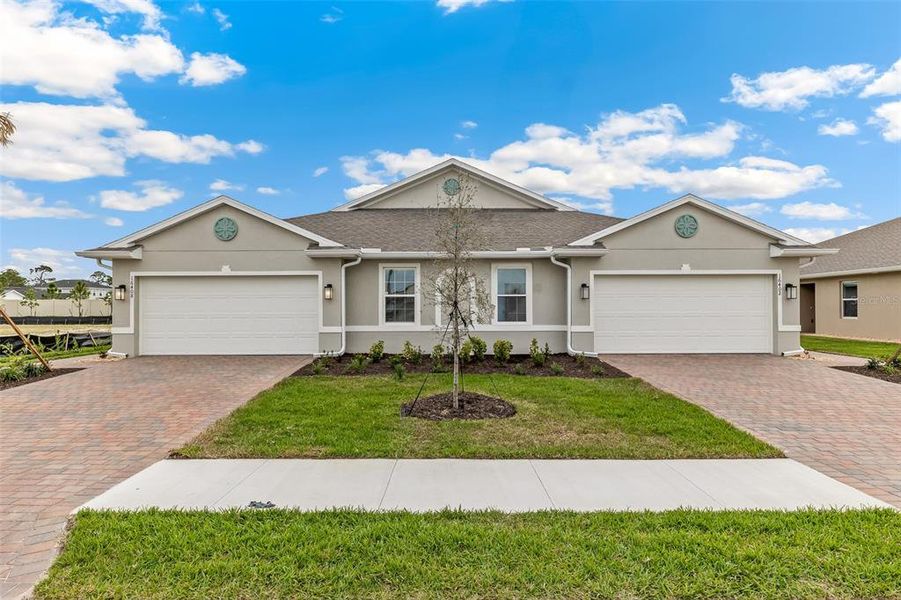 Front exterior of a new home in Cove at West Port - Express, Port Charlotte, FL, highlighting curb appeal (Image 1). Front exterior of a new home in Cove at West Port - Express, Port Charlotte, FL, highlighting curb appeal (Image 1).