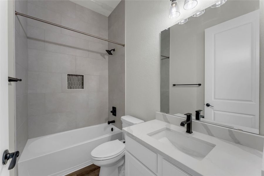 Bathroom featuring vanity, shower / tub combination, and dark wood finished floors