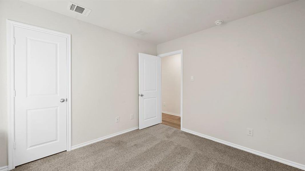 Unfurnished bedroom with carpet flooring and baseboards