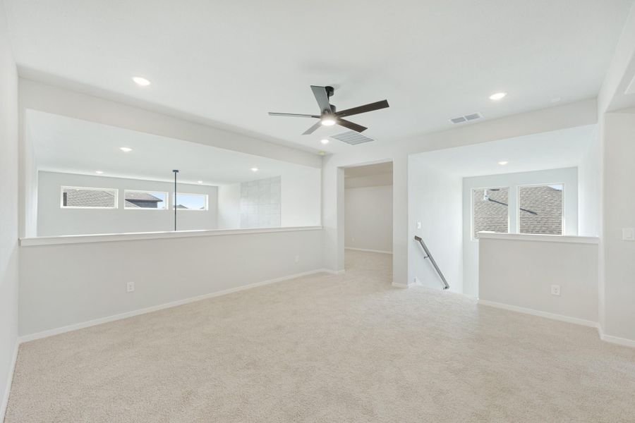 Empty upstairs loft with carpet, ceiling fan, recessed lighting, and staircase opening