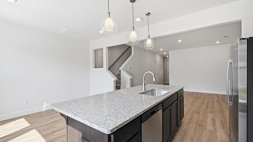 Tasteful design meets functional luxury in this kitchen with a 9-foot island and modern pendant lighting