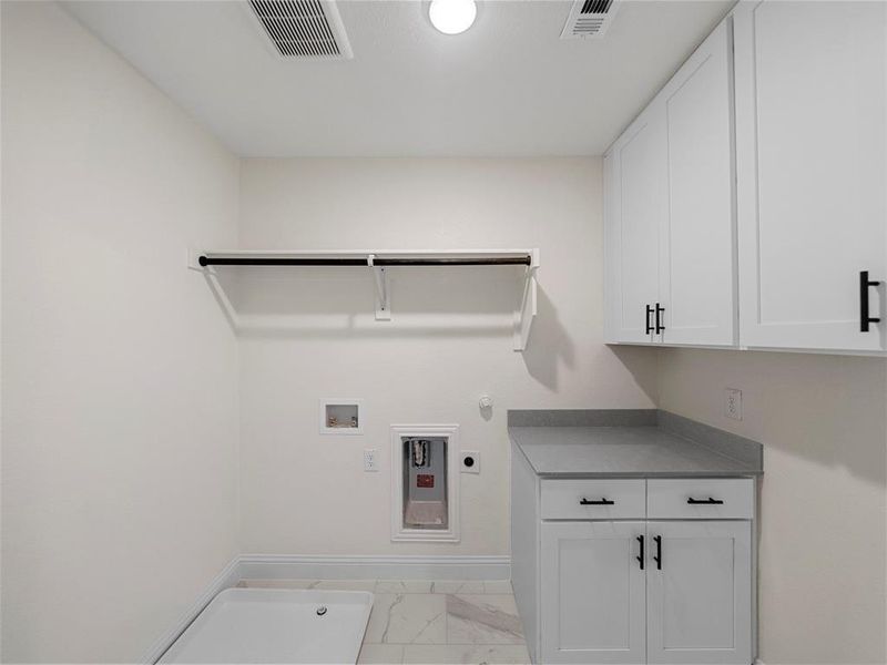 Laundry room featuring gas dryer hookup, electric dryer hookup, washer hookup, and cabinets