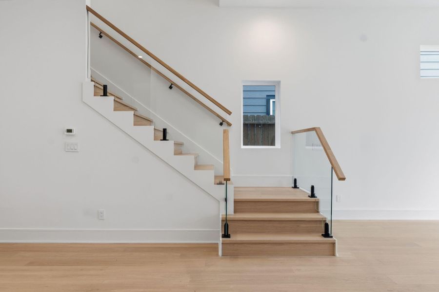 Solid Oak stair treads with glass railing system.