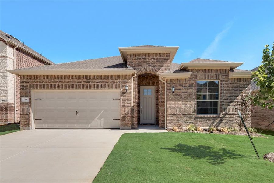 View of front of house featuring a garage and a front lawn