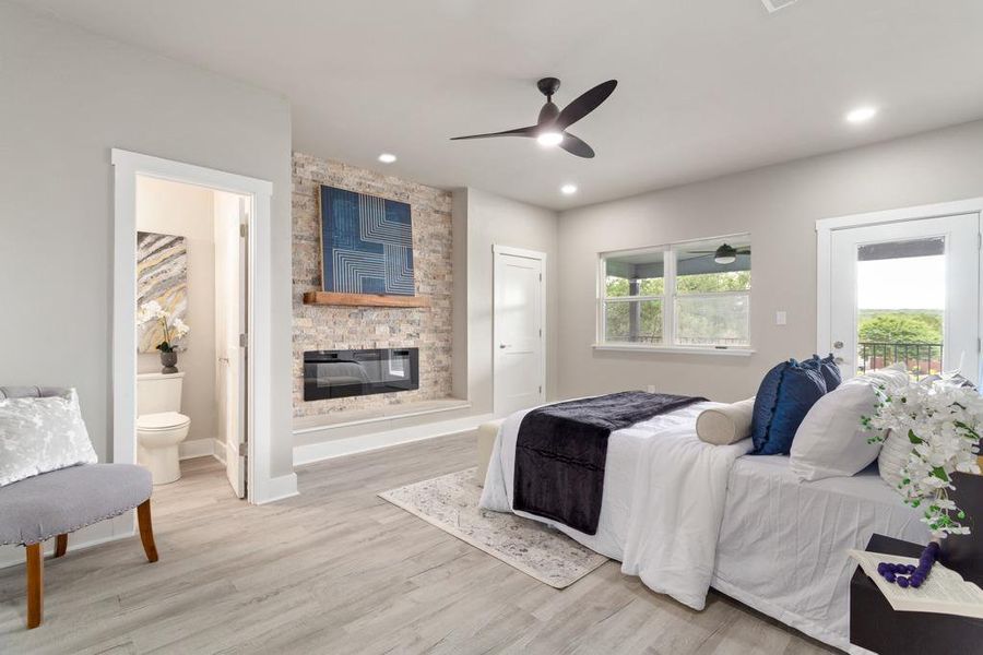A refined primary bedroom with a contemporary fireplace and private balcony access. A refined primary bedroom with a contemporary fireplace and private balcony access.