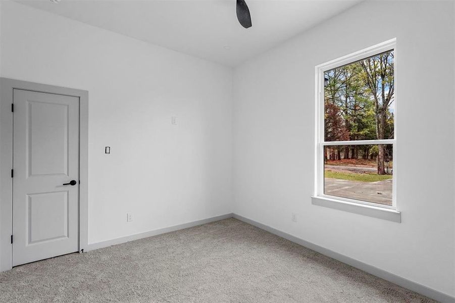 Unfurnished room featuring light carpet and ceiling fan