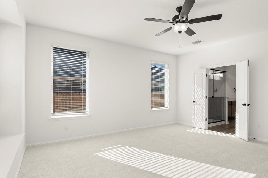 Unfurnished bedroom with carpet flooring, ensuite bath, and a ceiling fan