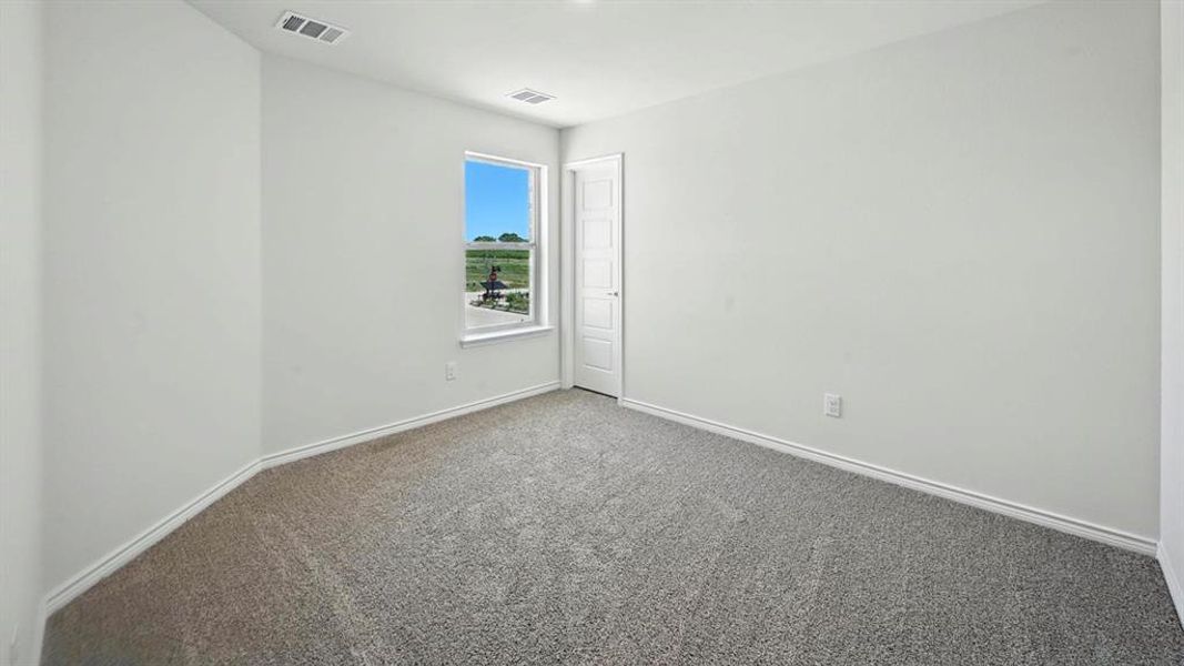 Empty room with carpet flooring and baseboards Empty room with carpet flooring and baseboards