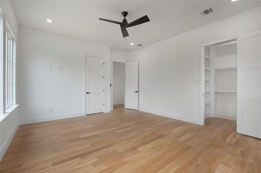 Unfurnished bedroom with light wood-type flooring, baseboards, recessed lighting, ceiling fan, and multiple windows Unfurnished bedroom with light wood-type flooring, baseboards, recessed lighting, ceiling fan, and multiple windows