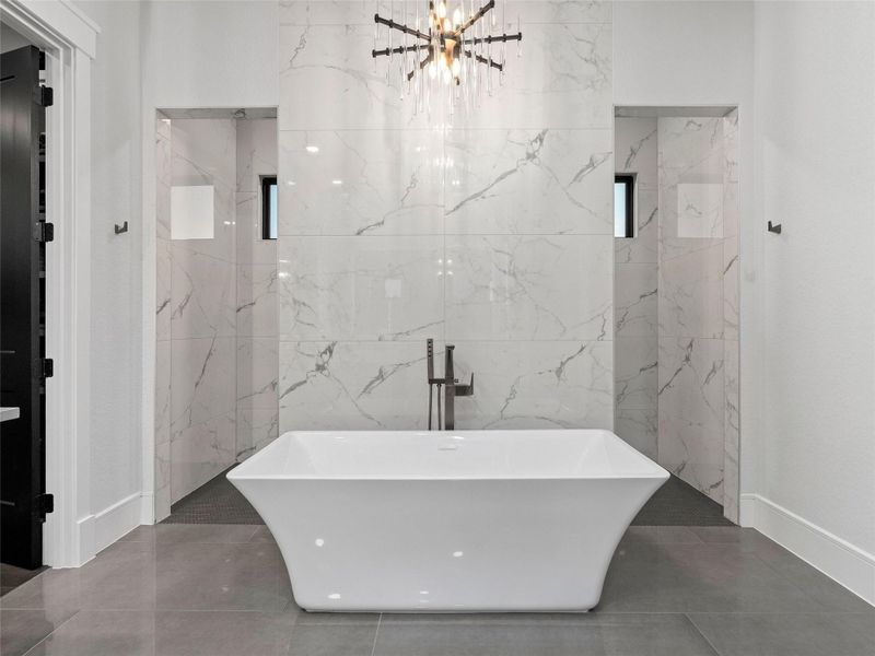Primary Bathroom featuring a freestanding bath, walk-through shower, tile patterned flooring, and tile walls
