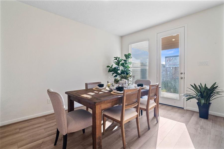 This lovely dining area is perfect for starting the day out on the right foot!  This space showcases custom paint, high ceilings, recessed lighting, large window adding to the ample natural light in the kitchen, and tile flooring!