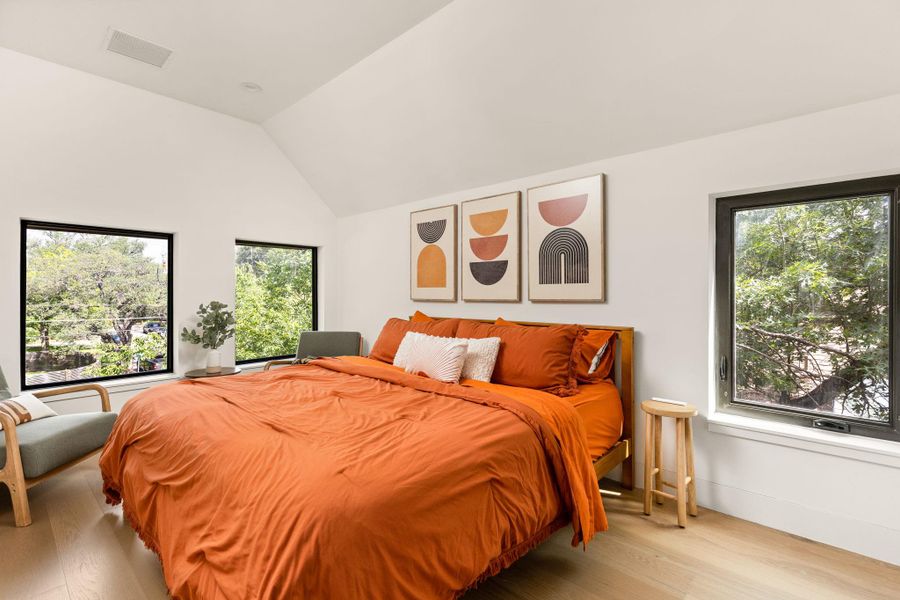Hardwood floors and a vaulted ceiling elevate this sun-filled bedroom. Hardwood floors and a vaulted ceiling elevate this sun-filled bedroom.