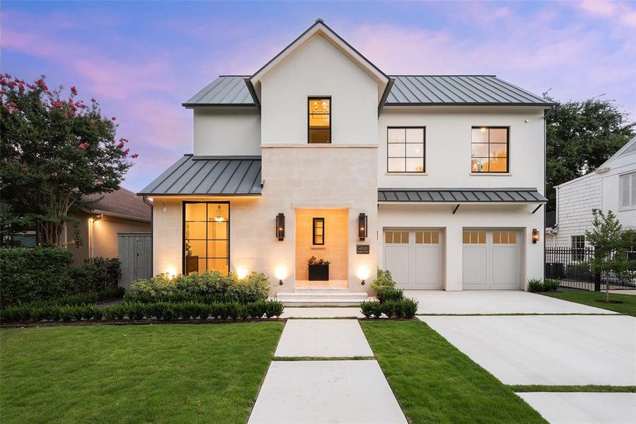 Modern inspired farmhouse featuring a garage and a lawn