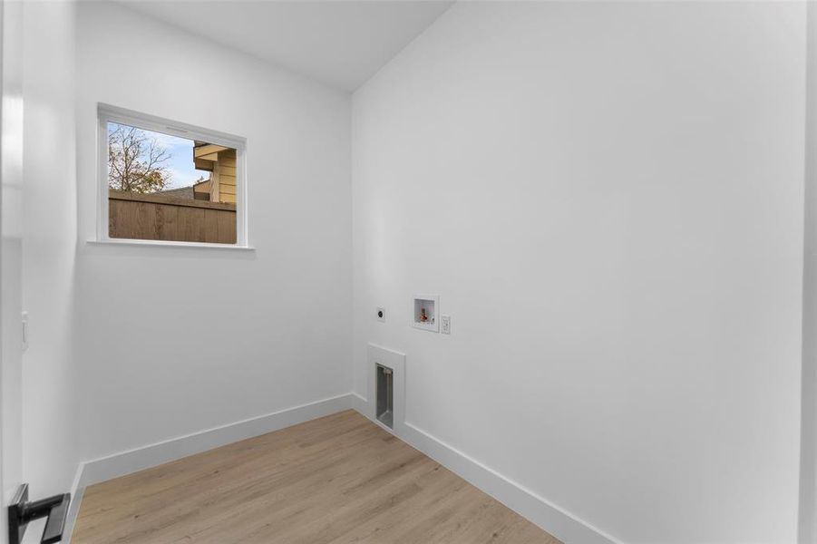 Laundry area with light wood finished floors, washer hookup, and electric dryer hookup