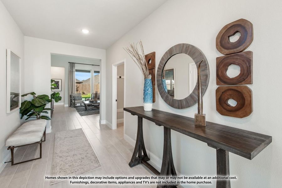 Bright entryway with console table, round mirror, wood wall art, and light tile floors leading to living room