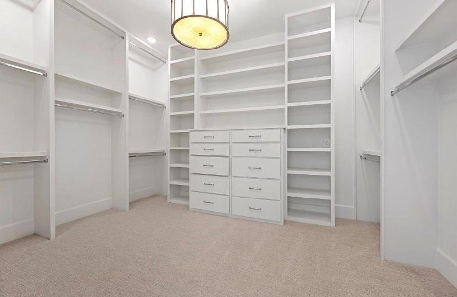 Walk in closet with light colored carpet