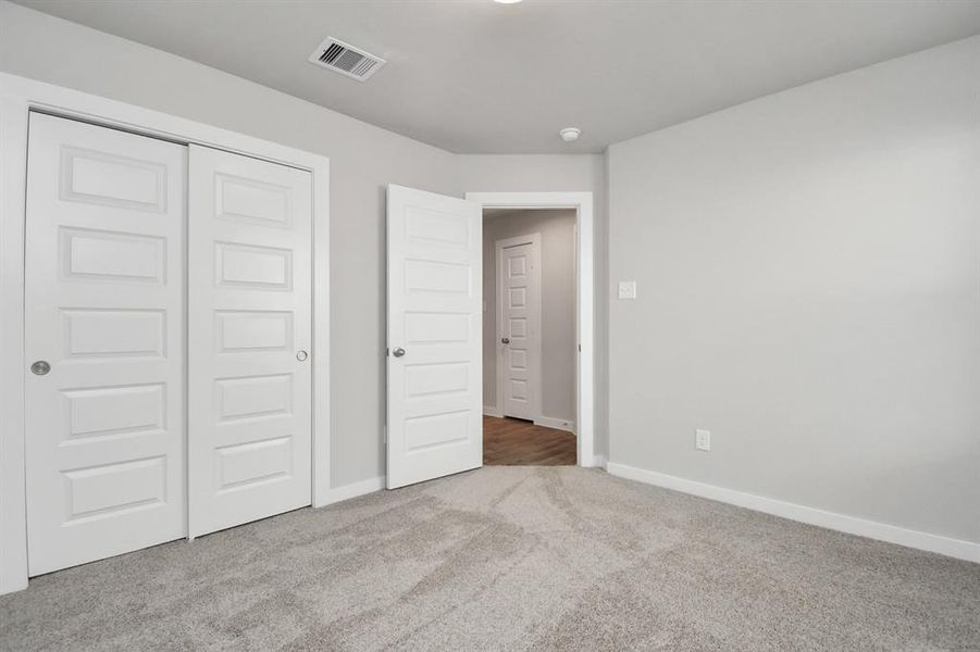 Secondary bedrooms showcase 5-panel doors adorned with modern hardware, large windows enhanced by privacy blinds, and spacious closets featuring sleek and contemporary finishes.