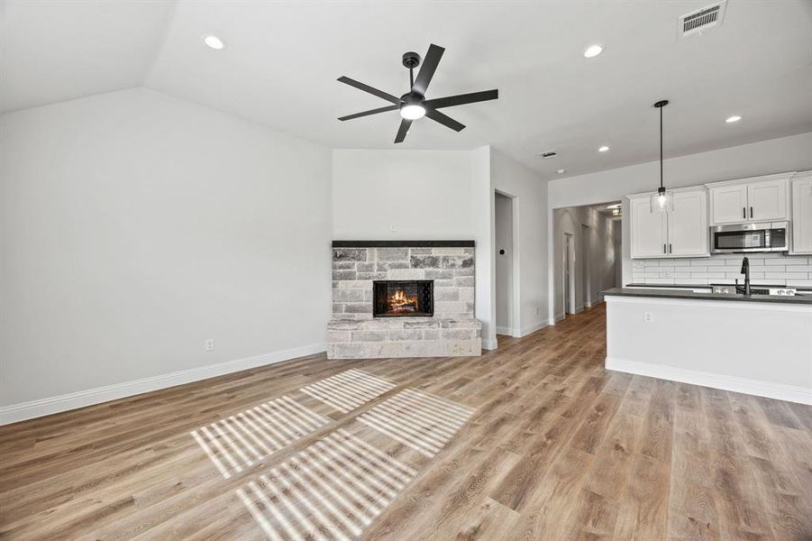 Unfurnished living room featuring light wood finished floors, recessed lighting, a fireplace, and ceiling fan