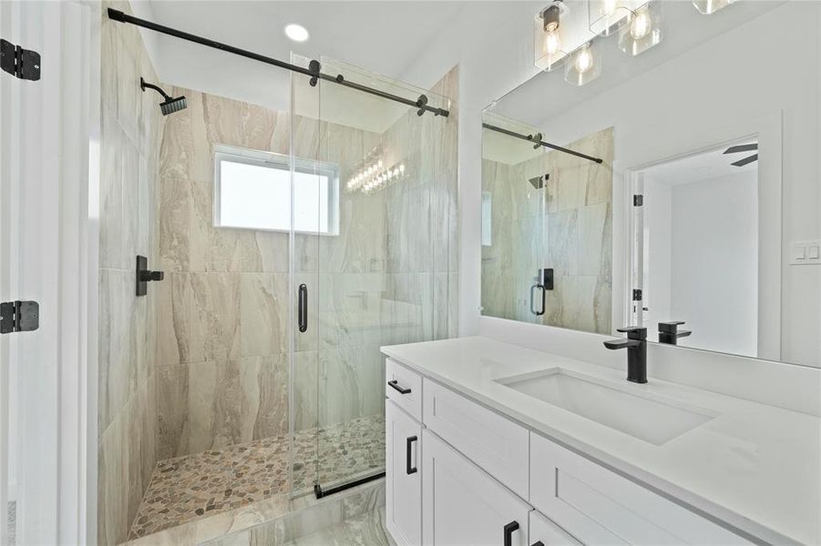 Bathroom featuring vanity and a marble finish shower Bathroom featuring vanity and a marble finish shower