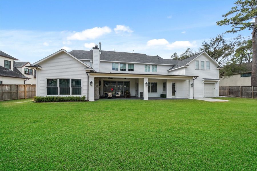 This view of the backyard highlights the back of the home, with a large patio and expansive windows.  The open space is perfect for adding a future pool, giving you countless possibilities for customization down the road.
