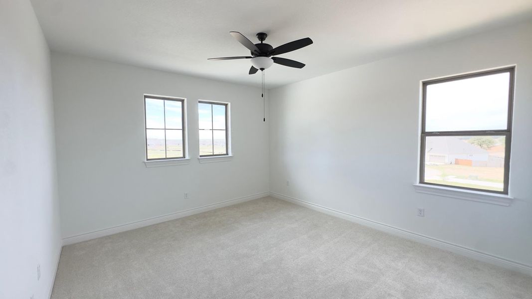 Unfurnished room featuring light colored carpet and ceiling fan