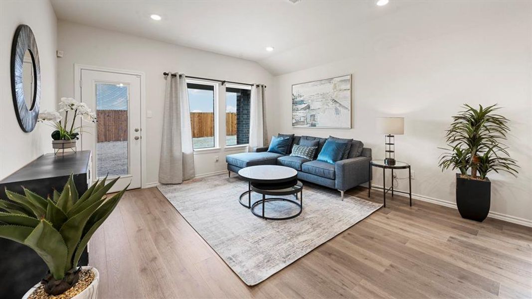 Living room with light wood-style flooring, recessed lighting, and lofted ceiling Living room with light wood-style flooring, recessed lighting, and lofted ceiling