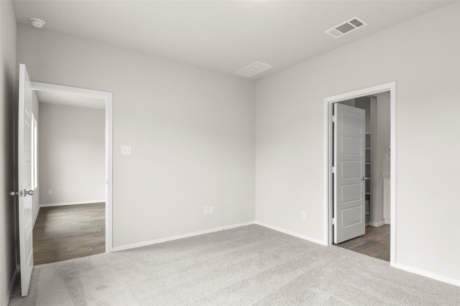 Unfurnished bedroom featuring carpet floors and a walk in closet