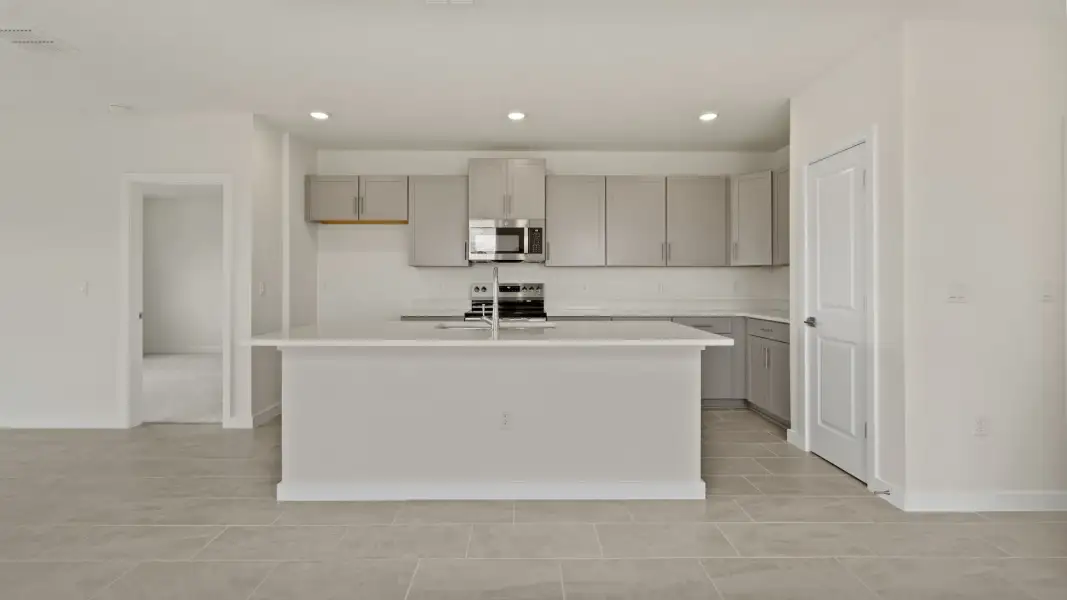 The Naples Kitchen with large Island Quick Move-In Home at Willowbrook North by DRB Homes in Winter Haven, FL