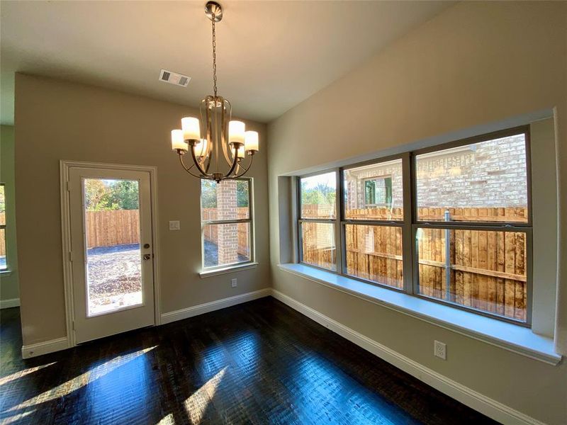 Cafe eating area off the kitchen with window seat and elegant Brushed Nickel chandelier